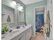 Well-lit bathroom with a double sink vanity and a decorative shower curtain visible through the doorway at 4502 Magnolia Ridge Dr, Waxhaw, NC 28173