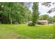 This backyard includes a lawn, mature trees, and storage shed with proximity to a brick home at 4533 Gainesborough Rd, Charlotte, NC 28205