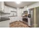 Well-lit kitchen with stainless steel appliances, white cabinets, and tile backsplash at 4533 Gainesborough Rd, Charlotte, NC 28205