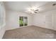 Spacious living area with new carpet, ceiling fan, and sliding glass door to patio at 4533 Gainesborough Rd, Charlotte, NC 28205