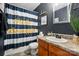 Bathroom featuring a dark painted wall, vanity with granite countertop, and navy blue shower curtain at 4916 Oak Pasture Ln, Charlotte, NC 28269