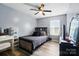 Bedroom featuring wood flooring, a queen bed, ceiling fan, and vanity area at 4916 Oak Pasture Ln, Charlotte, NC 28269