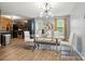Bright dining area featuring a modern glass table, stylish chairs, and contemporary lighting fixture at 4916 Oak Pasture Ln, Charlotte, NC 28269