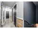 Hallway featuring gray wood flooring, wood paneling, dark colored doors, and a railing at 4916 Oak Pasture Ln, Charlotte, NC 28269