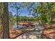 A charming dock with bench seating overlooks a tranquil lake surrounded by lush trees and a scenic path at 5002 Samoa Ridge Dr, Lancaster, SC 29270