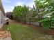 Backyard with green grass and trees bordering a wooden fence at 5306 Prosperity View Dr, Charlotte, NC 28269