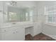 Bright bathroom vanity with double sinks, white cabinets, framed mirror, and tile flooring at 5306 Prosperity View Dr, Charlotte, NC 28269