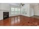 Spacious living room with hardwood floors, a fireplace, and multiple windows offering plenty of natural light at 5306 Prosperity View Dr, Charlotte, NC 28269