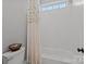 Bright bathroom showcases a white tiled shower with a patterned curtain, complemented by a toilet and woven basket at 536 Spring Landing Dr, Rock Hill, SC 29730
