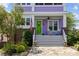 Charming front porch with rocking chairs, flag, potted plants, a green door and a welcoming brick and stone entryway at 536 Spring Landing Dr, Rock Hill, SC 29730