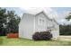 Side view of a home with light gray siding, green grass, and a wooden fence at 585 Gentle Breeze Ln, Rock Hill, SC 29730