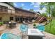 Backyard patio with dining area and lounge chairs surrounded by lush greenery and mature trees at 625 S Magnolia St, Mooresville, NC 28115