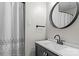Simple bathroom featuring a modern vanity, dark fixtures, and a shower/tub with a decorative curtain at 625 S Magnolia St, Mooresville, NC 28115