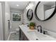 Bathroom featuring double sinks, modern lighting, and a window at 625 S Magnolia St, Mooresville, NC 28115