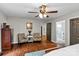 Cozy bedroom featuring a ceiling fan, hardwood floors, and an ensuite bathroom for added convenience and privacy at 625 S Magnolia St, Mooresville, NC 28115