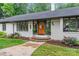 Inviting home entrance with a wooden door, brick steps, and lush landscaping at 625 S Magnolia St, Mooresville, NC 28115
