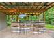 Outdoor bar with a wooden counter, barstools, a mounted TV, and string lights at 625 S Magnolia St, Mooresville, NC 28115