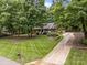 Beautiful, long driveway leads to a brick home surrounded by mature trees and a manicured lawn at 635 Timberlane Trl, Salisbury, NC 28147