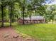 Serene backyard with a brick house, white fence, and lush greenery creates a tranquil outdoor oasis at 635 Timberlane Trl, Salisbury, NC 28147