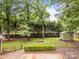 Expansive backyard featuring a wooden fence, fire pit, and storage shed, perfect for outdoor enjoyment at 635 Timberlane Trl, Salisbury, NC 28147