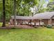 A spacious backyard with a brick home, white picket fence, well-kept lawn, and mature trees offers an outdoor retreat at 635 Timberlane Trl, Salisbury, NC 28147