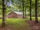 Picturesque backyard with a brick house, a white fence, and mature trees provides a private and relaxing atmosphere at 635 Timberlane Trl, Salisbury, NC 28147