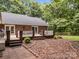 Brick home showcasing a backyard patio with steps, landscaping with mature trees, and a fenced yard at 635 Timberlane Trl, Salisbury, NC 28147