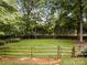 Spacious backyard with a wooden fence, mature trees, and lush lawn, providing a private outdoor retreat at 635 Timberlane Trl, Salisbury, NC 28147