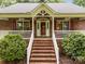 Inviting front porch with brick steps, white railings, and red door framed by lush greenery at 635 Timberlane Trl, Salisbury, NC 28147