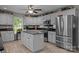 Well-lit kitchen with gray cabinets, stainless steel appliances, and an island at 635 Timberlane Trl, Salisbury, NC 28147