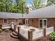 Brick home featuring an outdoor patio with dining set, grill, fenced yard, and lush landscaping at 635 Timberlane Trl, Salisbury, NC 28147