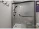 Modern bathroom with a tiled walk-in shower featuring a glass door, shower head, and safety bar at 635 Timberlane Trl, Salisbury, NC 28147