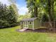 Charming backyard storage shed with a ramp and white trim, adding functionality to the outdoor space at 635 Timberlane Trl, Salisbury, NC 28147