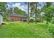 Large backyard showcasing the home's brick exterior, screened porch, and stone patio area at 7050 Knightswood Dr, Charlotte, NC 28226