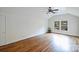 Spacious bedroom with hardwood floors, ceiling fan, and large windows offering ample natural light at 7050 Knightswood Dr, Charlotte, NC 28226