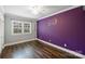 Bedroom featuring hardwood floors, a window, and a colorful accent wall at 7050 Knightswood Dr, Charlotte, NC 28226