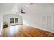 Bright bedroom with large window, hardwood floors, ceiling fan, and white walls perfect for creating a serene retreat at 7050 Knightswood Dr, Charlotte, NC 28226