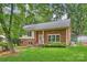 Beautifully landscaped yard showcasing a classic brick facade, windows, and front entrance with steps at 7050 Knightswood Dr, Charlotte, NC 28226