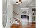 Inviting foyer with hardwood floors, a staircase with wood and black metal railings, and views into the kitchen at 7050 Knightswood Dr, Charlotte, NC 28226