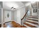 Welcoming foyer with hardwood floors, a staircase with wood railings, and a view of the front door at 7050 Knightswood Dr, Charlotte, NC 28226