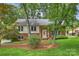 Charming brick home with lush front yard and mature trees, offering a serene and inviting curb appeal at 7050 Knightswood Dr, Charlotte, NC 28226