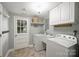 Well-lit laundry room with white cabinets, washer, and dryer at 7050 Knightswood Dr, Charlotte, NC 28226
