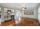 Spacious living room with open layout to kitchen, custom built-ins, natural light, and hardwood floors at 7050 Knightswood Dr, Charlotte, NC 28226
