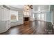 Open-concept living room with hardwood floors, brick fireplace, and custom built-in shelving at 7050 Knightswood Dr, Charlotte, NC 28226