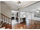 Open-concept living space with hardwood floors, staircase, and bar leading to the kitchen, perfect for entertaining at 7050 Knightswood Dr, Charlotte, NC 28226