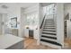 Hallway featuring black and white staircase, wet bar with wine cooler and modern cabinets at 790 Herrons Ferry Rd, Rock Hill, SC 29730