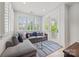 Sunroom-style living area with gray sectional sofa, striped rug, and a white window with many panes at 790 Herrons Ferry Rd, Rock Hill, SC 29730