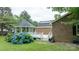 Backyard with brick home, deck, gazebo, mature trees, and vibrant hydrangea bushes at 8259 Camelia Ln, Denver, NC 28037