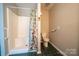 Bathroom features a tiled shower with a floral curtain, toilet, and dark flooring at 8259 Camelia Ln, Denver, NC 28037