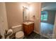 Half-bath features a toilet and a vanity with a wood cabinet at 8259 Camelia Ln, Denver, NC 28037